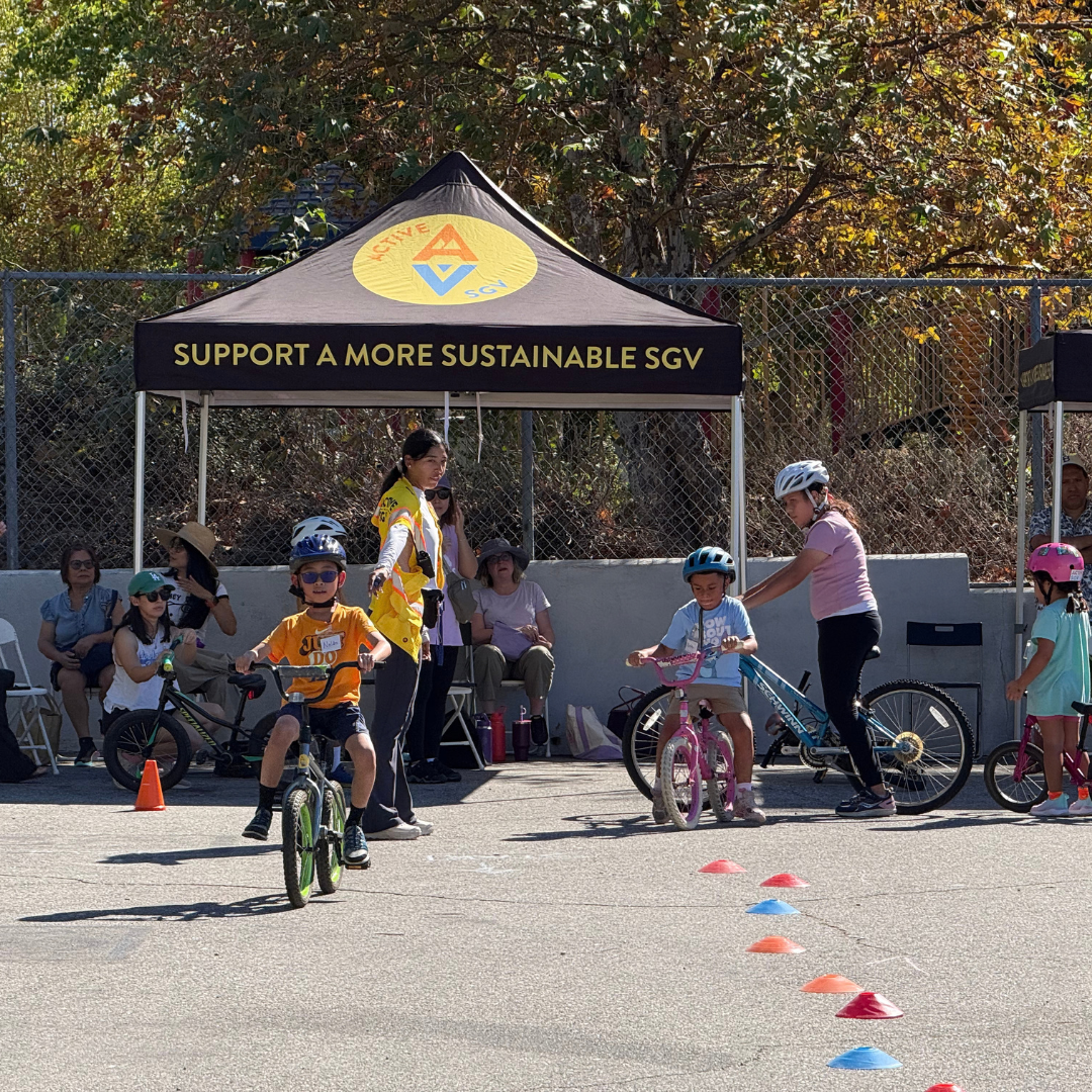 Children lined up on bikes underneath an ActiveSGV canopy