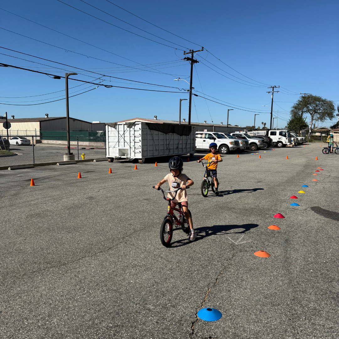 Two children biking through an obstacle course.