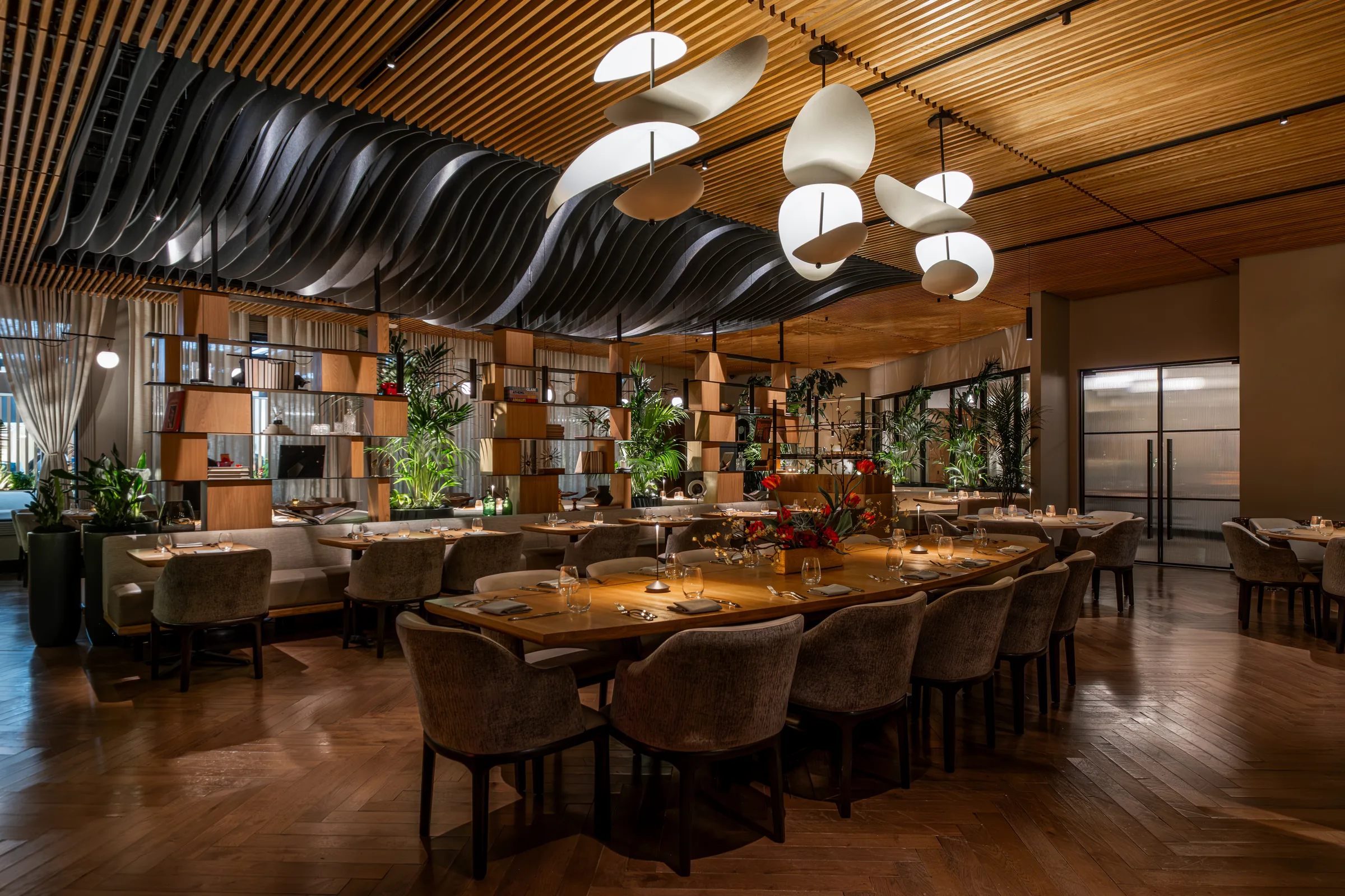 BOA Steakhouse main dining room with sculpted wood ceiling baffles, wood slat walls, and dining tables