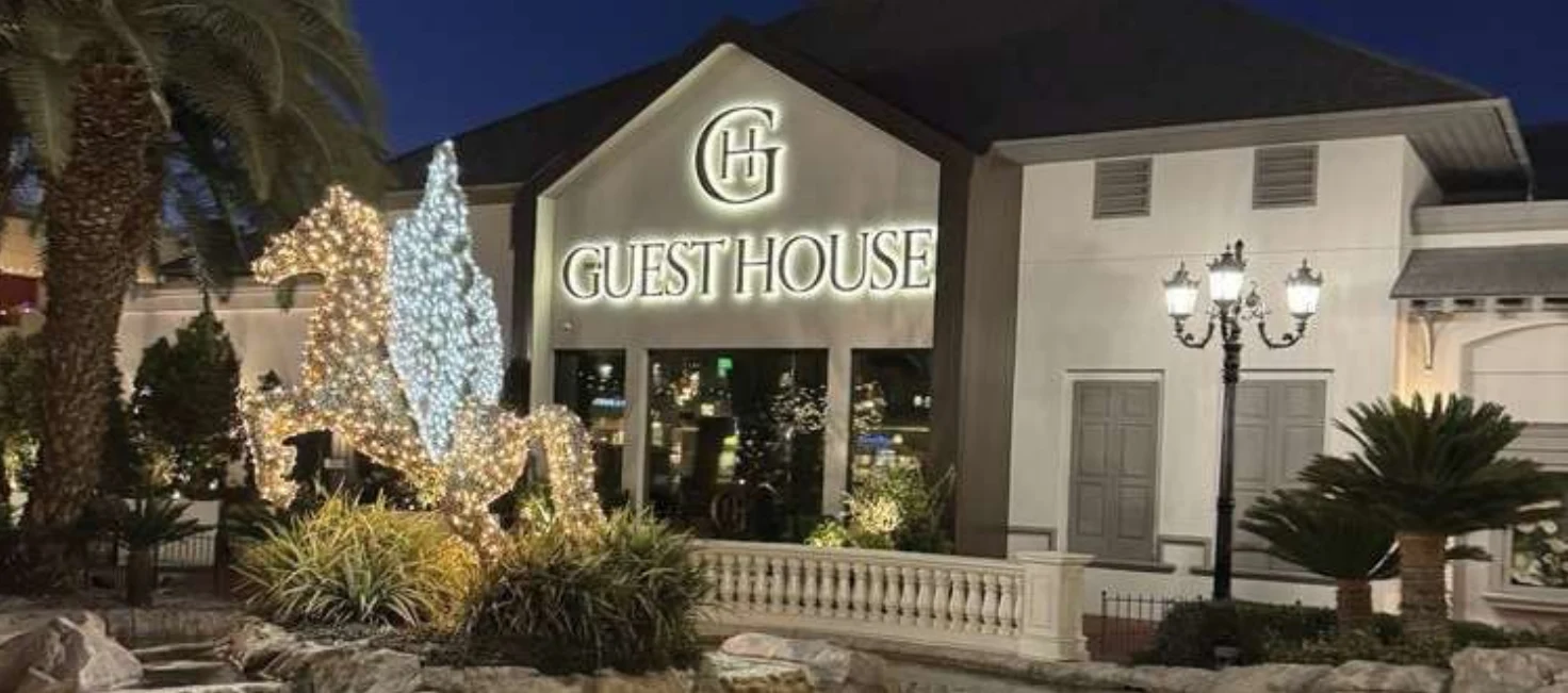 The Guest House illuminated entrance and landscaped patio at Town Square