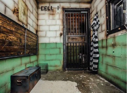 Prison-themed escape room with cell doors and distressed wall finishes