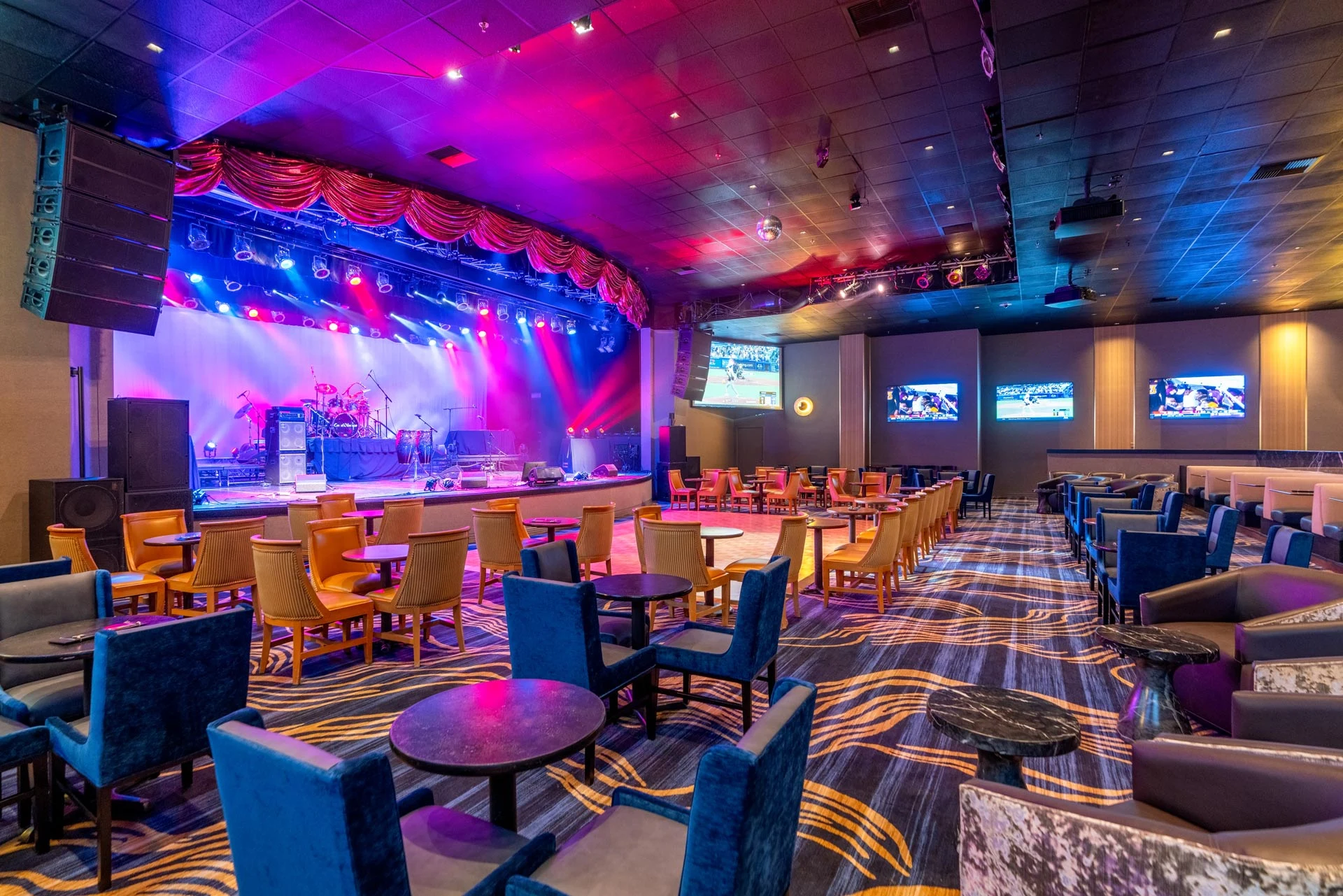 CasaBlanca Showroom interior with illuminated stage, upholstered seating, and wall-mounted screens