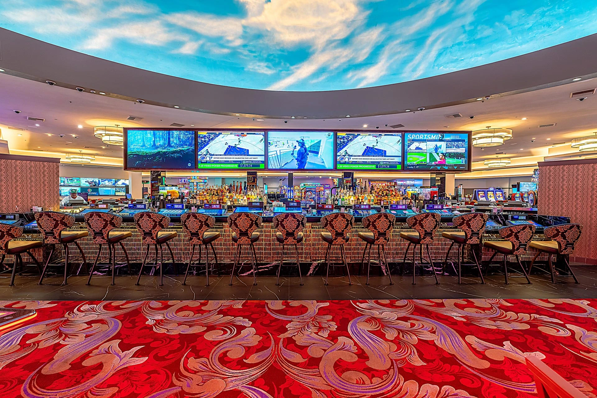 CasaBlanca bar with a blue sky ceiling, patterned seating, video poker counters and overhead televisions