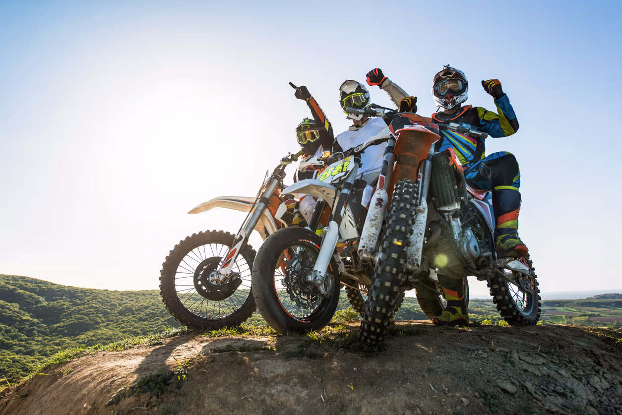Team of successful motorcyclist on top of the hill