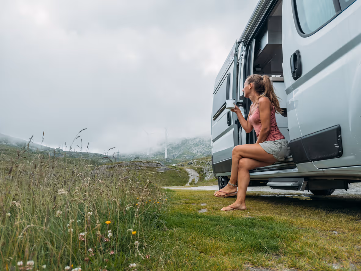 Woman Relaxing Outside Camper Van in Nature