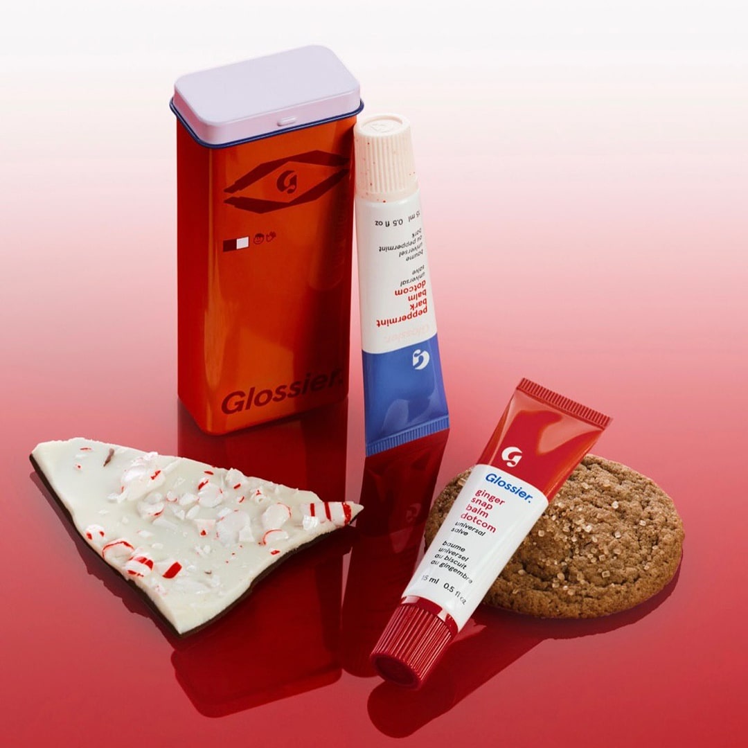 High-key red flat lay featuring skincare cream, serum, and decorative elements arranged together.