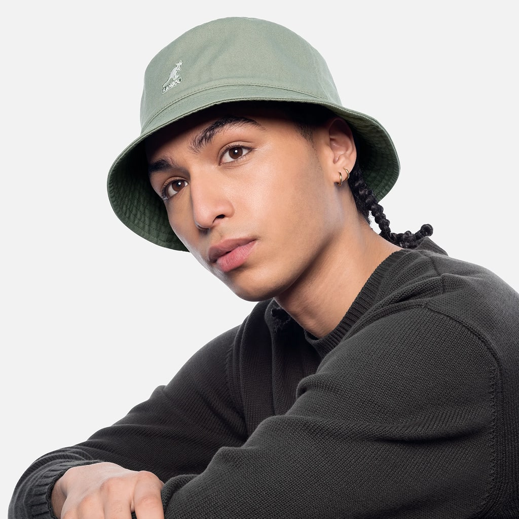 Lifestyle portrait of a model wearing a green bucket hat