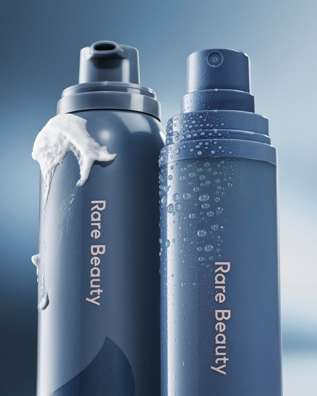 Blue skincare spray bottles with water droplets on a blue background