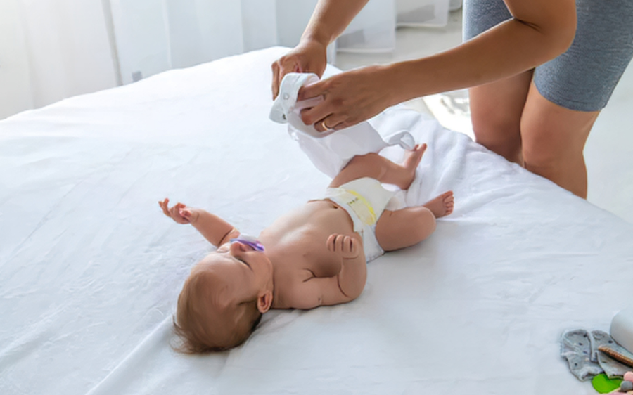 Baby after getting dirty diaper changed by mom