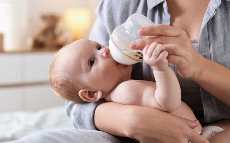 baby holding moms and while being bottle fed