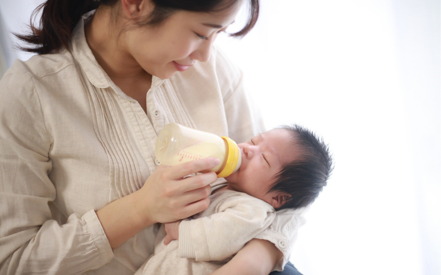 mom bottle feeding newborn baby