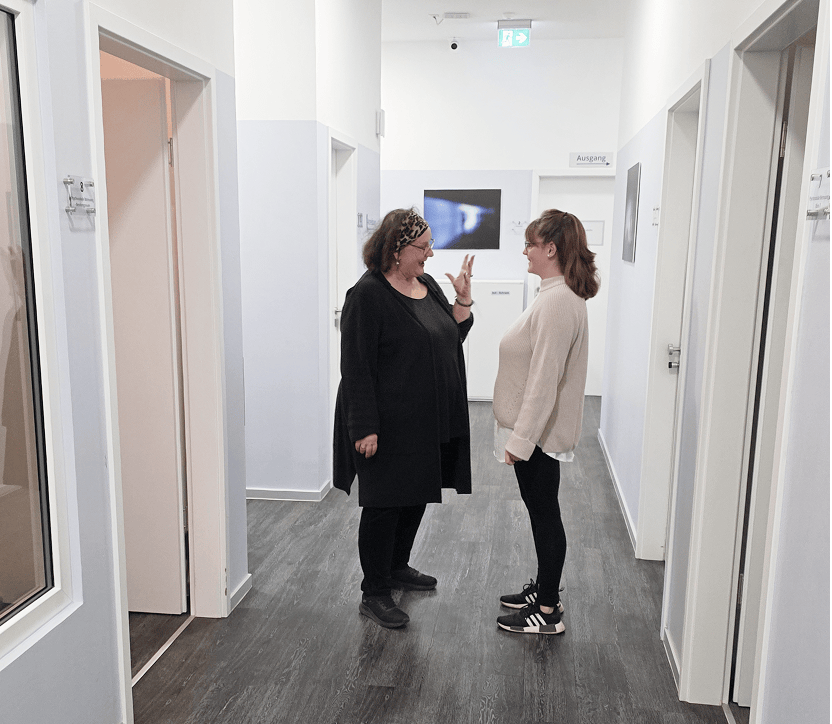 Zwei Frauen im Gespräch im Flur der Praxis Lyonn