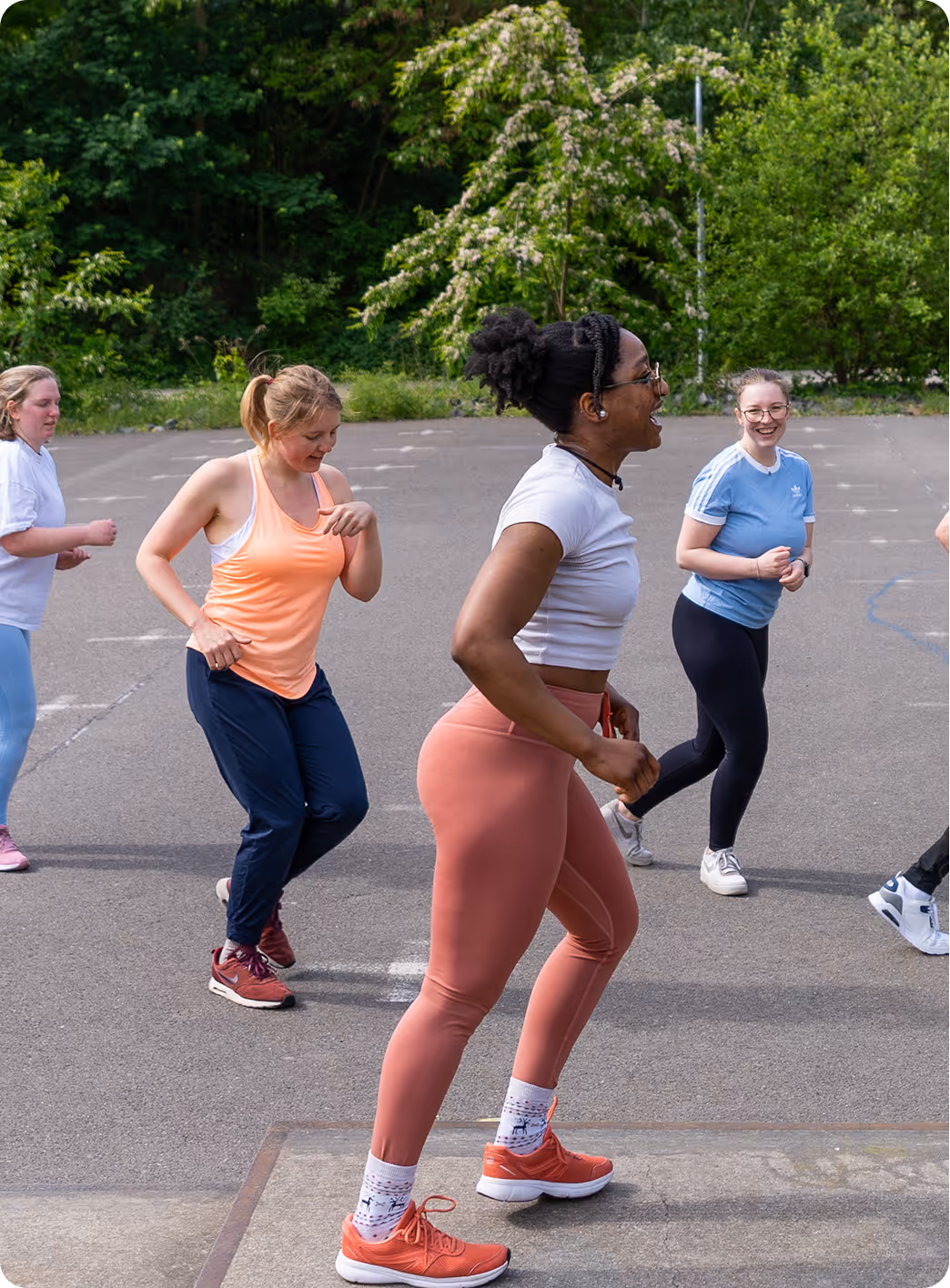 Kerline Charles, female fitness trainer at Spicy Fit Nation, leading a Spicy Rumba group class with a group of trainees dancing in the background, showcasing energy, movement and community.