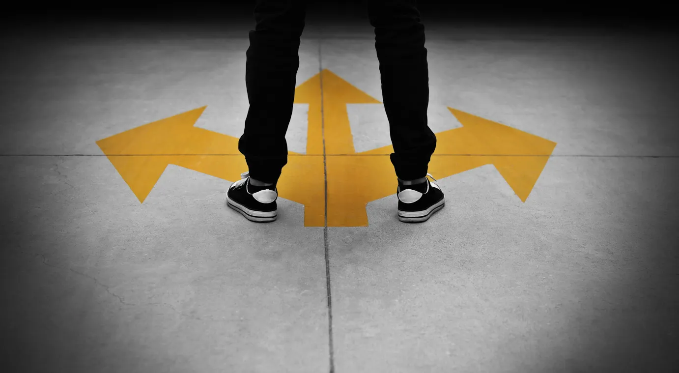 Man standing on crossroad sign