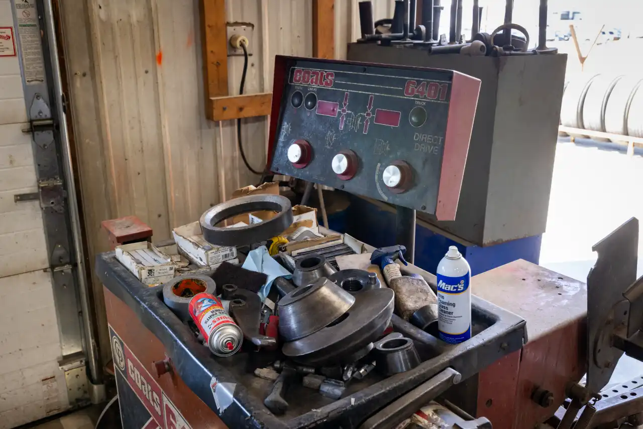 Truck alignment machine with G401 control panel and scattered parts, including Mac’s Foaming Degreaser spray can. 