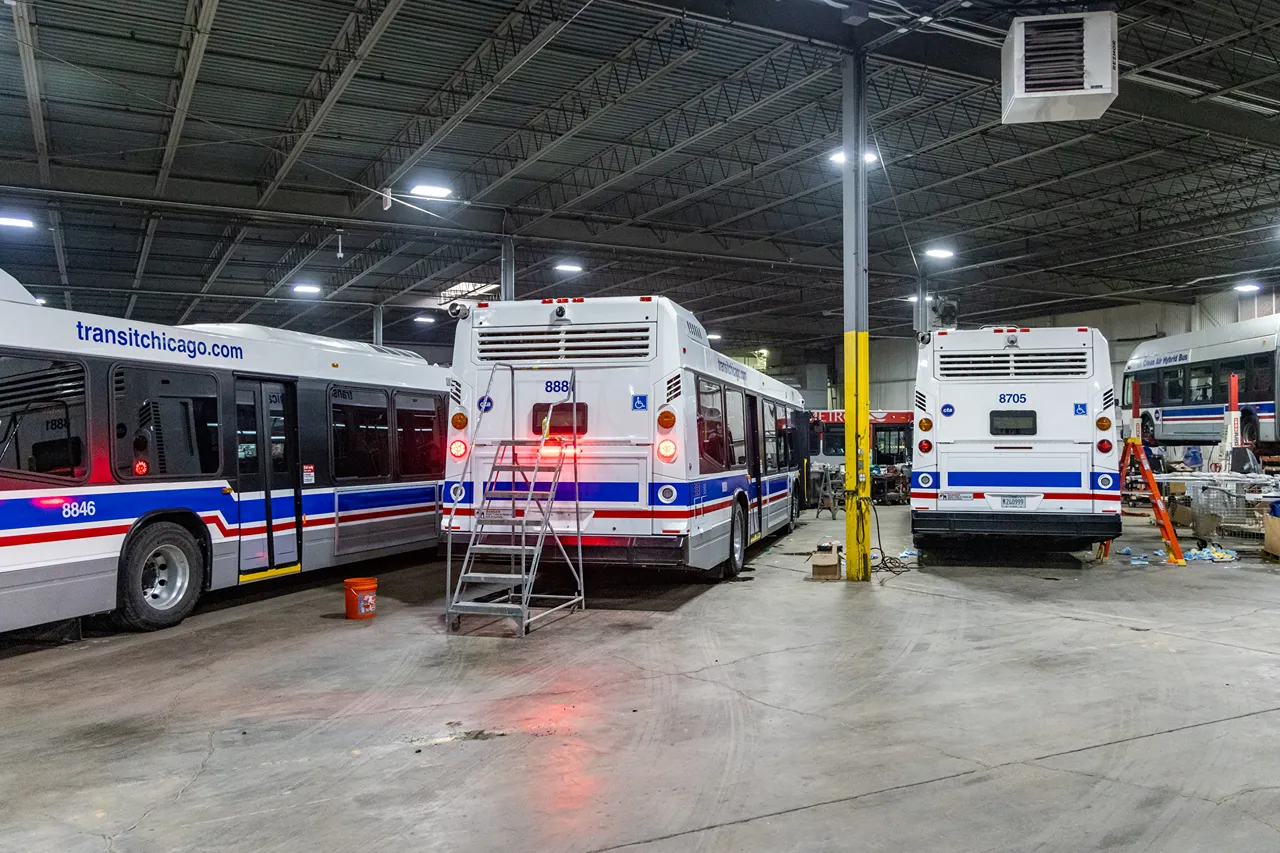Bus fleet services underway on CTA buses in a heavy-duty repair shop, with “transitchicago.com” visible.