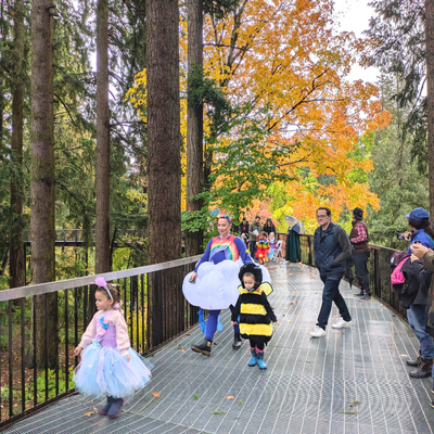 Children in Halloween costumes walking through a garden