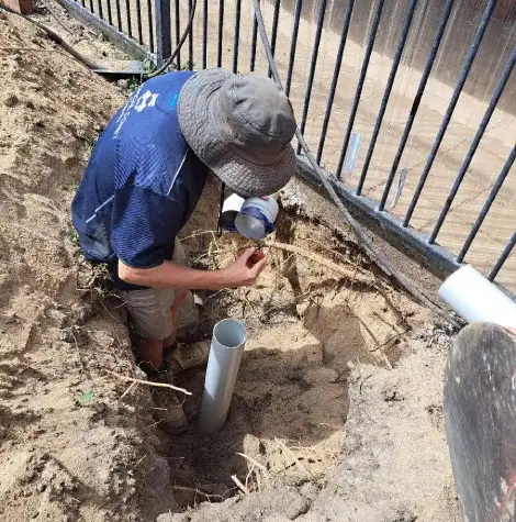 A plumber preparing to repair PVC drainage pipes as part of a blocked drain service.