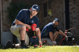 Tropical Coast Plumbing technician using electronic leak detection equipment in a Yeppoon yard to locate underground pipes.