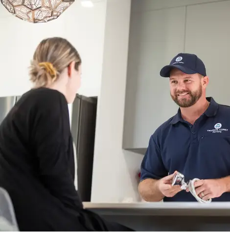Local plumbing specialist explaining blocked drain repairs and drainage services to a customer in Townsville.