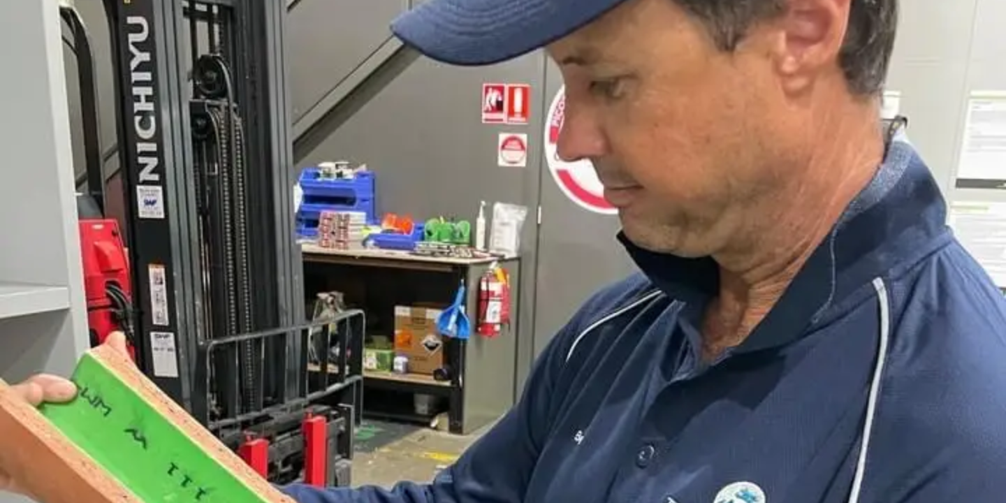 Townsville plumber showing a section of relined pipe, demonstrating the trenchless no-dig repair process used for damaged pipes.