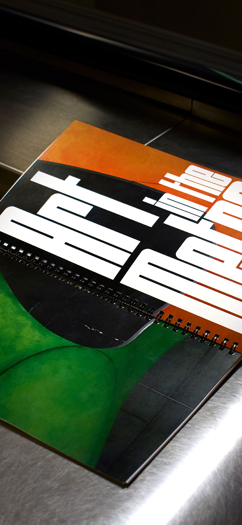 Book design opened and laid down flat on the side of a metro escalator (to show the back and front cover of the book). The image is high contrast to mimic the spots of bright lighting in the metro vs the dark corners of the metro.