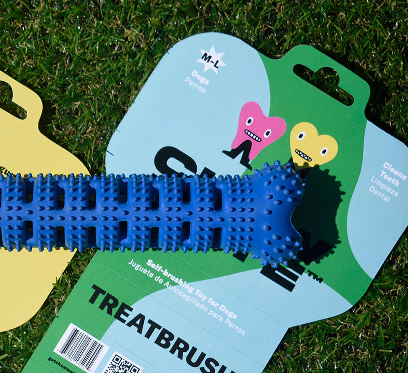 Photograph of inside and outside of the Treatbrush™ packaging with the product placed on top