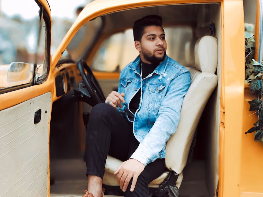young man sitting in front seat of car - maine auto insurance for young drivers