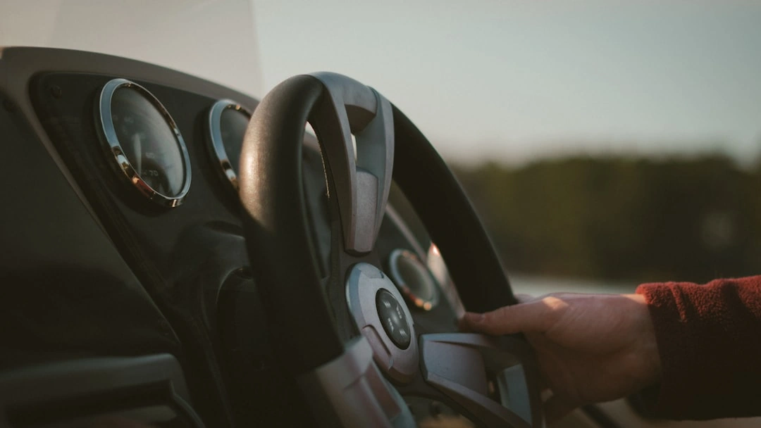 hands behind wheel of car - car insurance for 1st time drivers concept