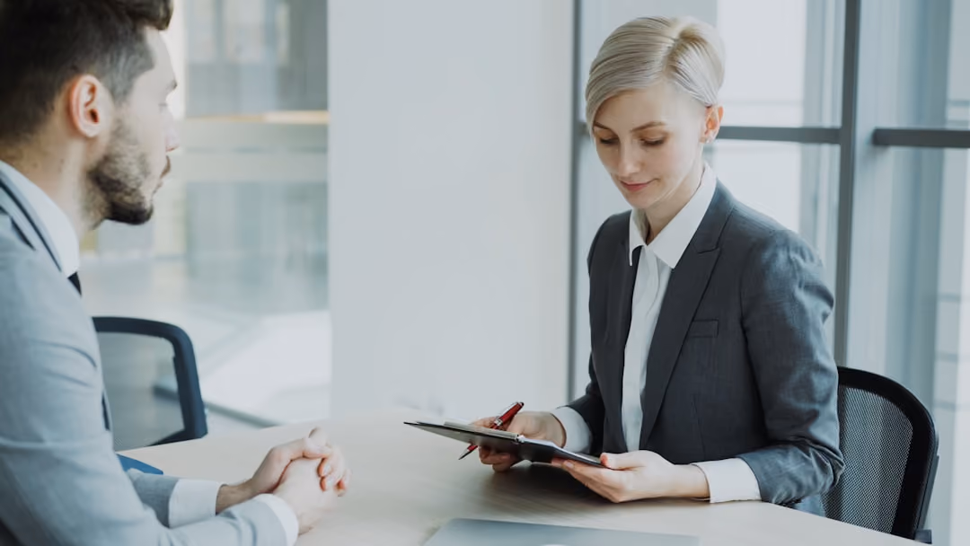 Professional insurance agent reviewing auto policy documents with a client Professional insurance agent reviewing auto policy documents with a client