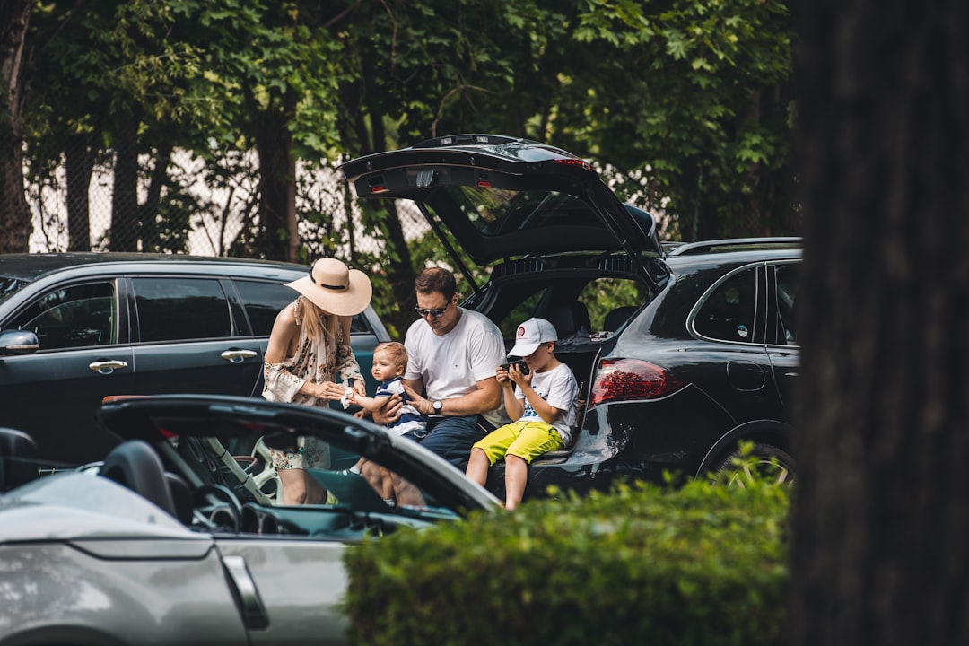 A happy family packing their SUV for a summer weekend road trip in Wells, Maine