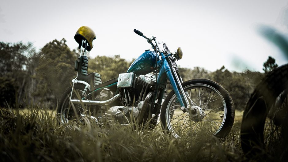 motorcycle with helmet on it in a maine field- maine motorcycle custom chopper insurance concept