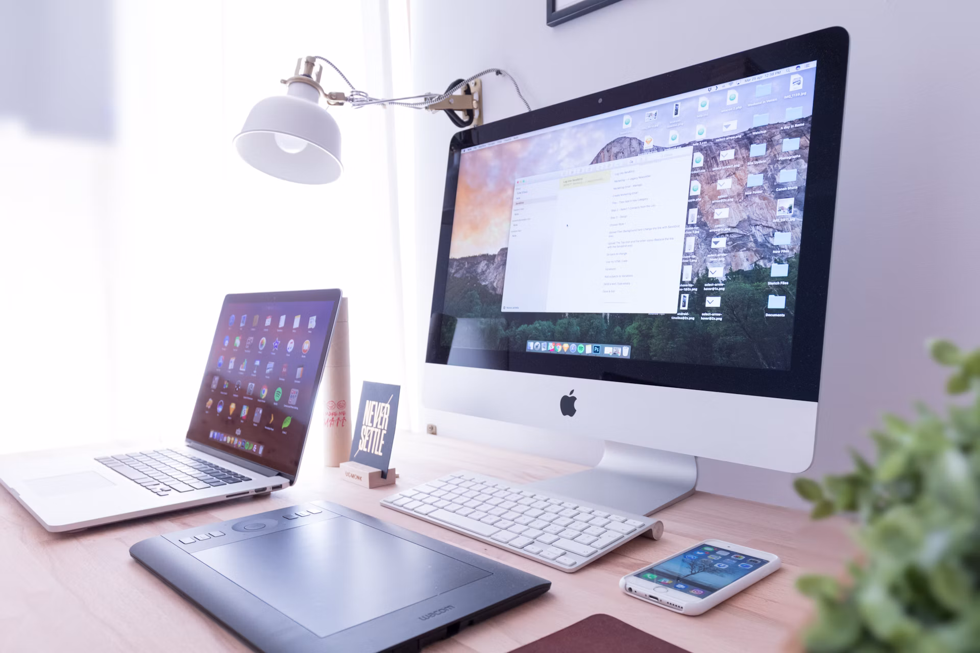 iMac und iPhone nebeneinander auf einem Holztisch als Symbolbild für responsives Webdesign auf Desktop und Mobilgeräten