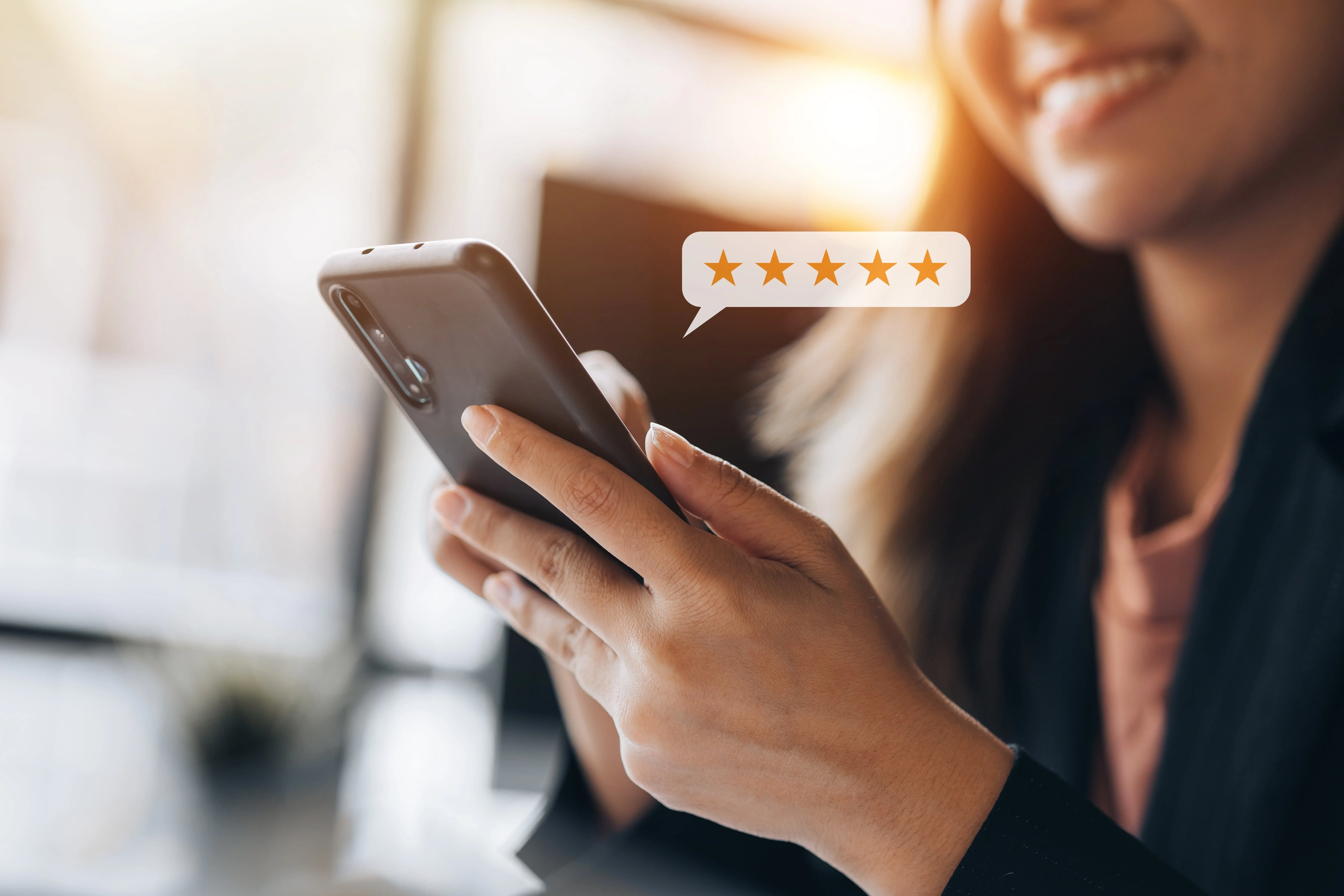 Smiling woman holding a smartphone with a five-star rating graphic above the phone.