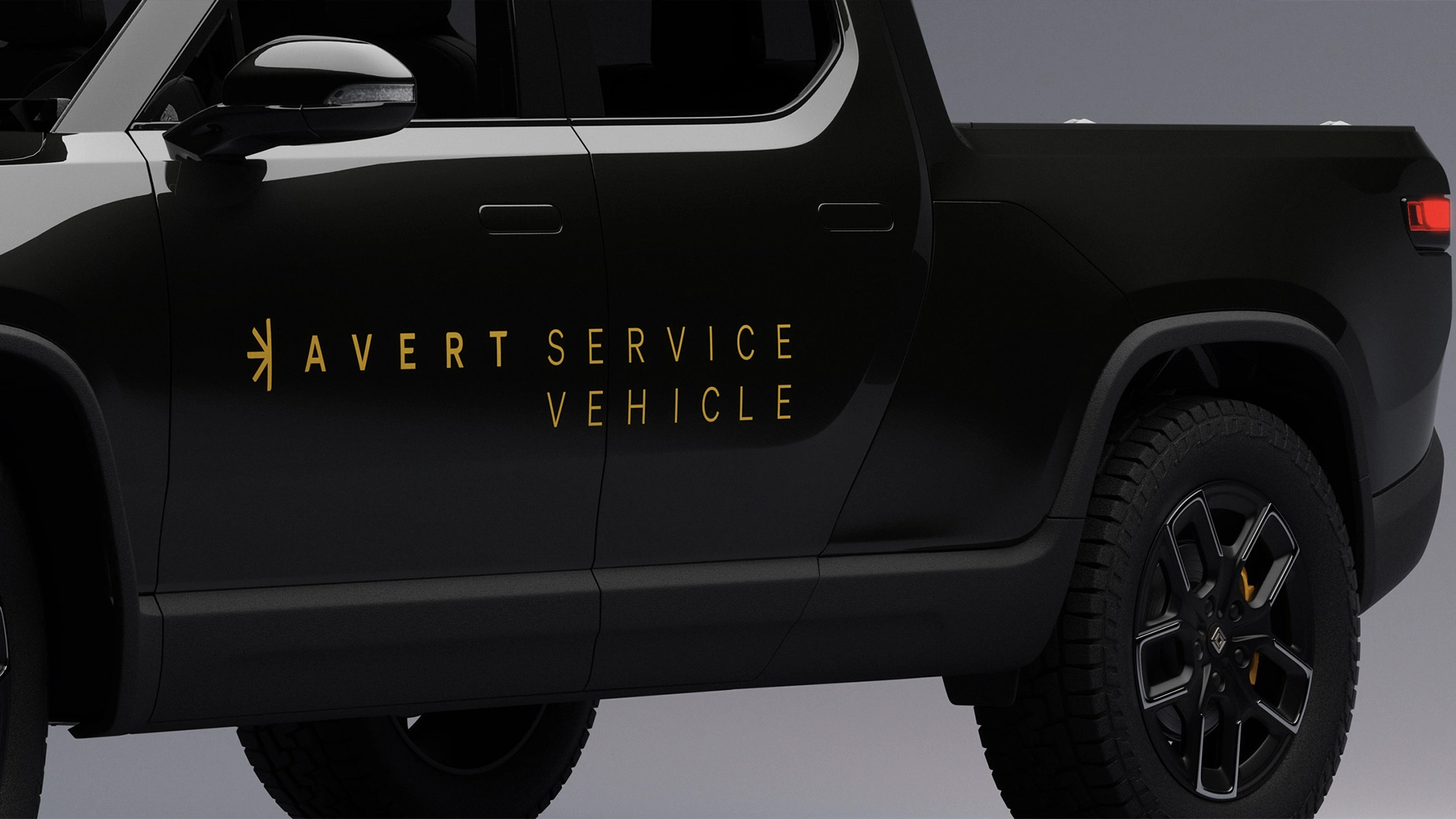 Side view of a black pickup truck with yellow text reading 'Avert Service Vehicle' on the door.
