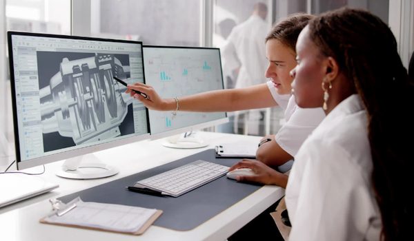 Designers travaillant sur une modélisation 3D affichée sur deux écrans