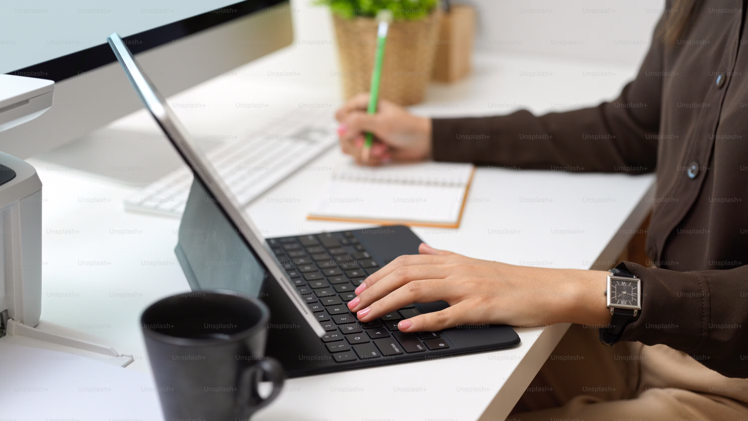 Personne travaillant sur une tablette avec clavier, un stylo à la main