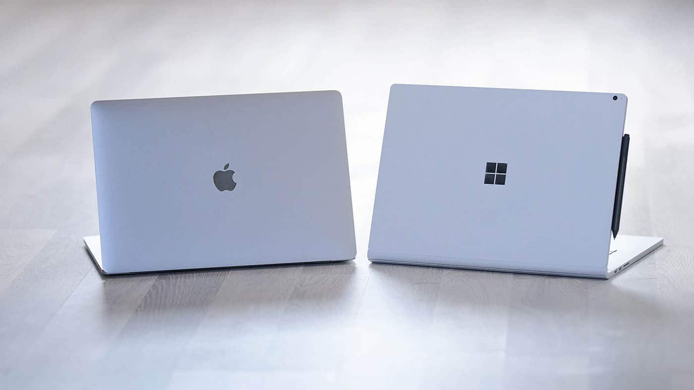 MacBook et Surface Laptop posés côte à côte, capots fermés