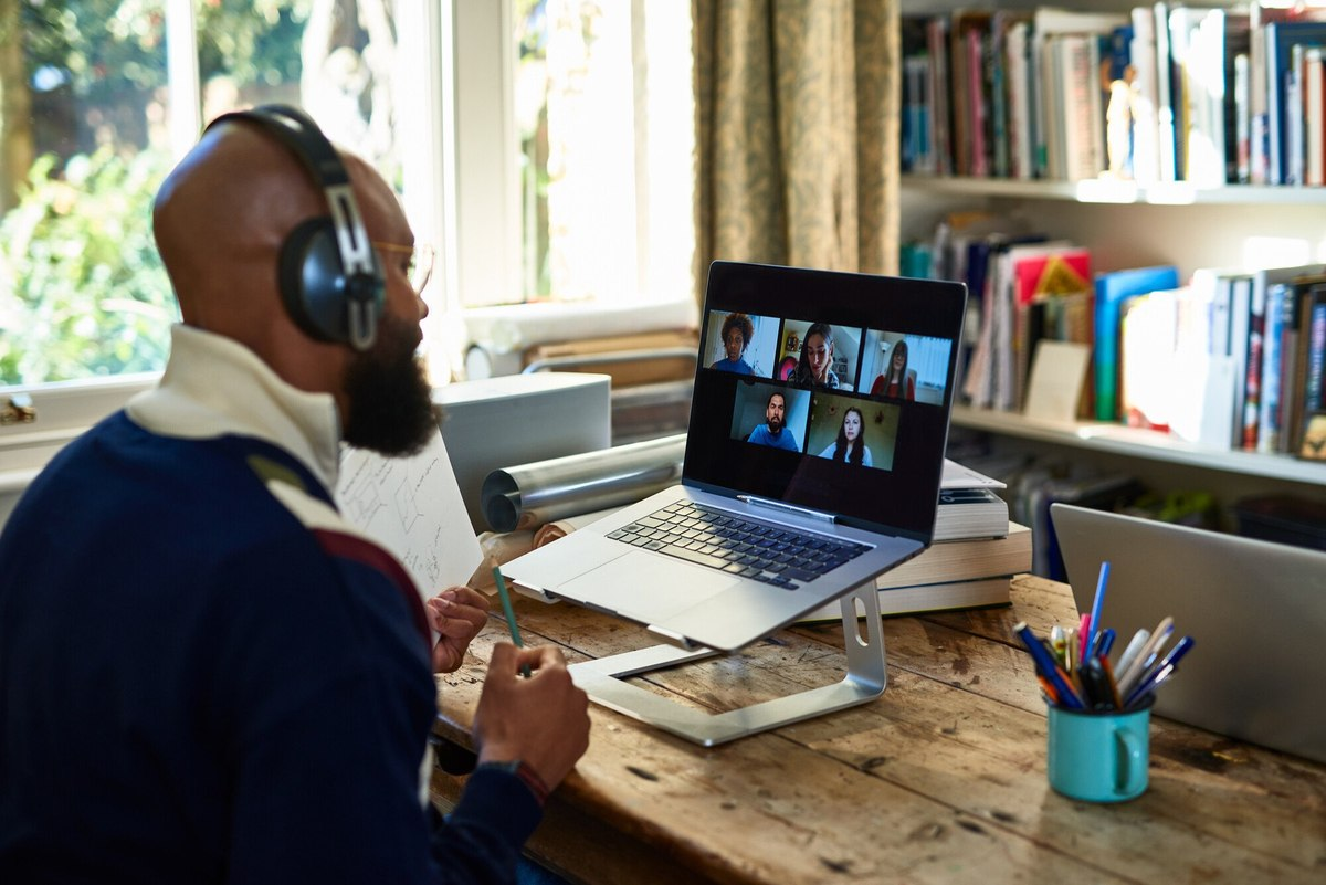 Homme en visioconférence avec un casque devant un ordinateur portable reconditionné