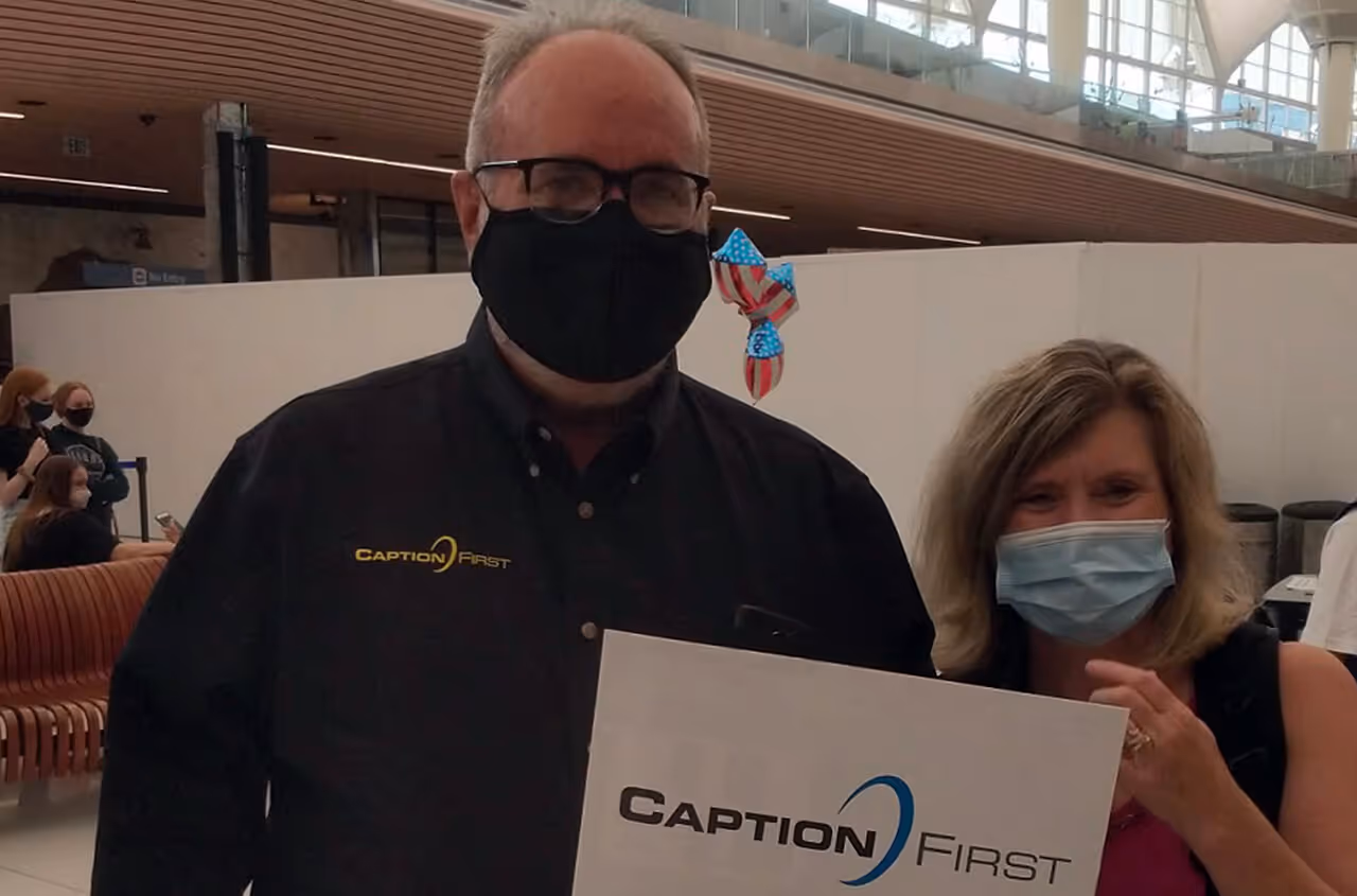 caption first team outing - two standing with masks and sign