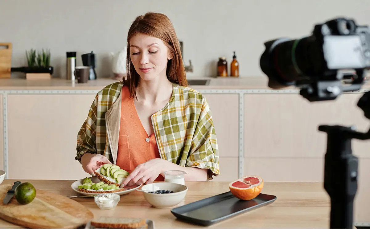 Female setting up food in front of a camera