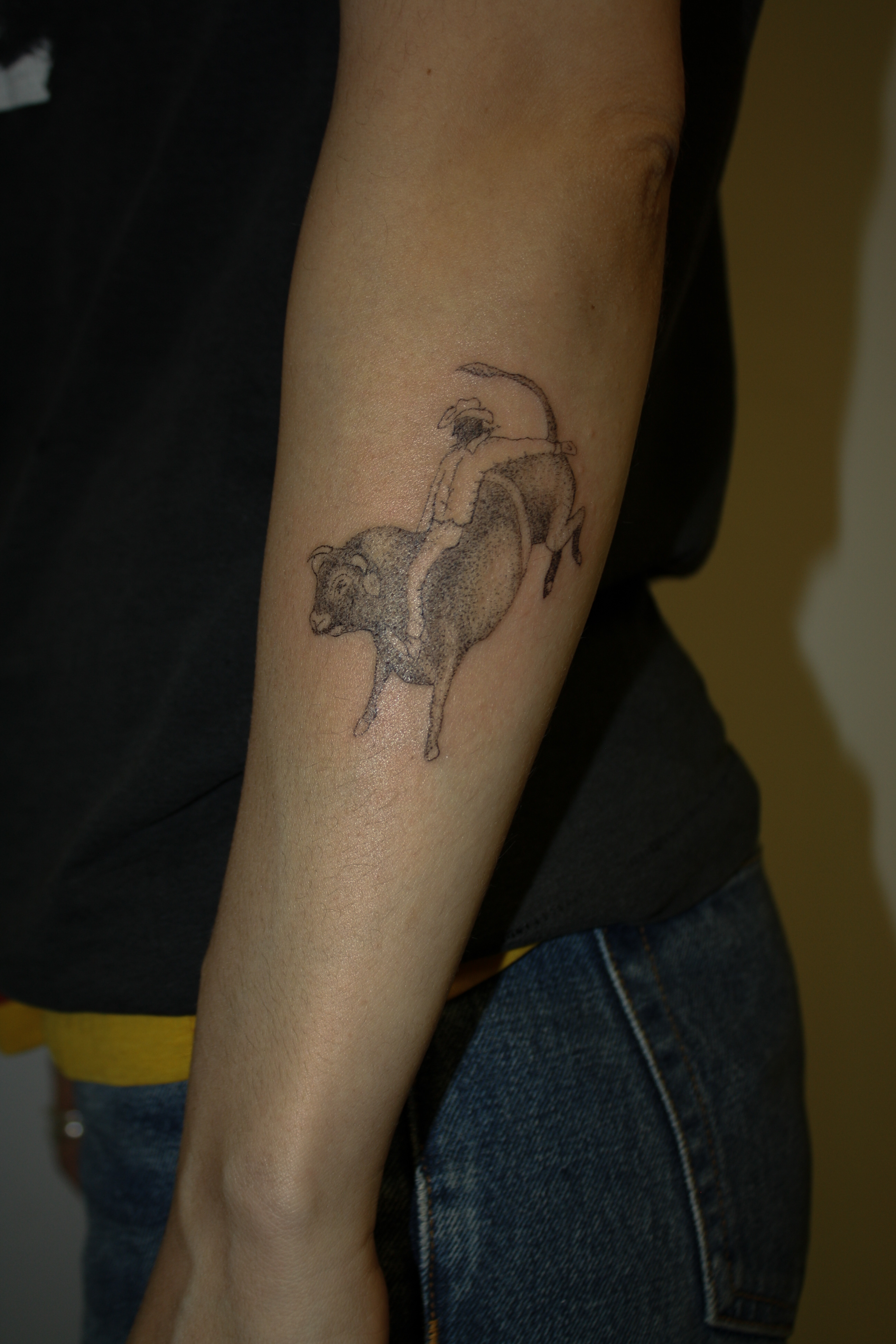 bull rider tattoo on outer forearm