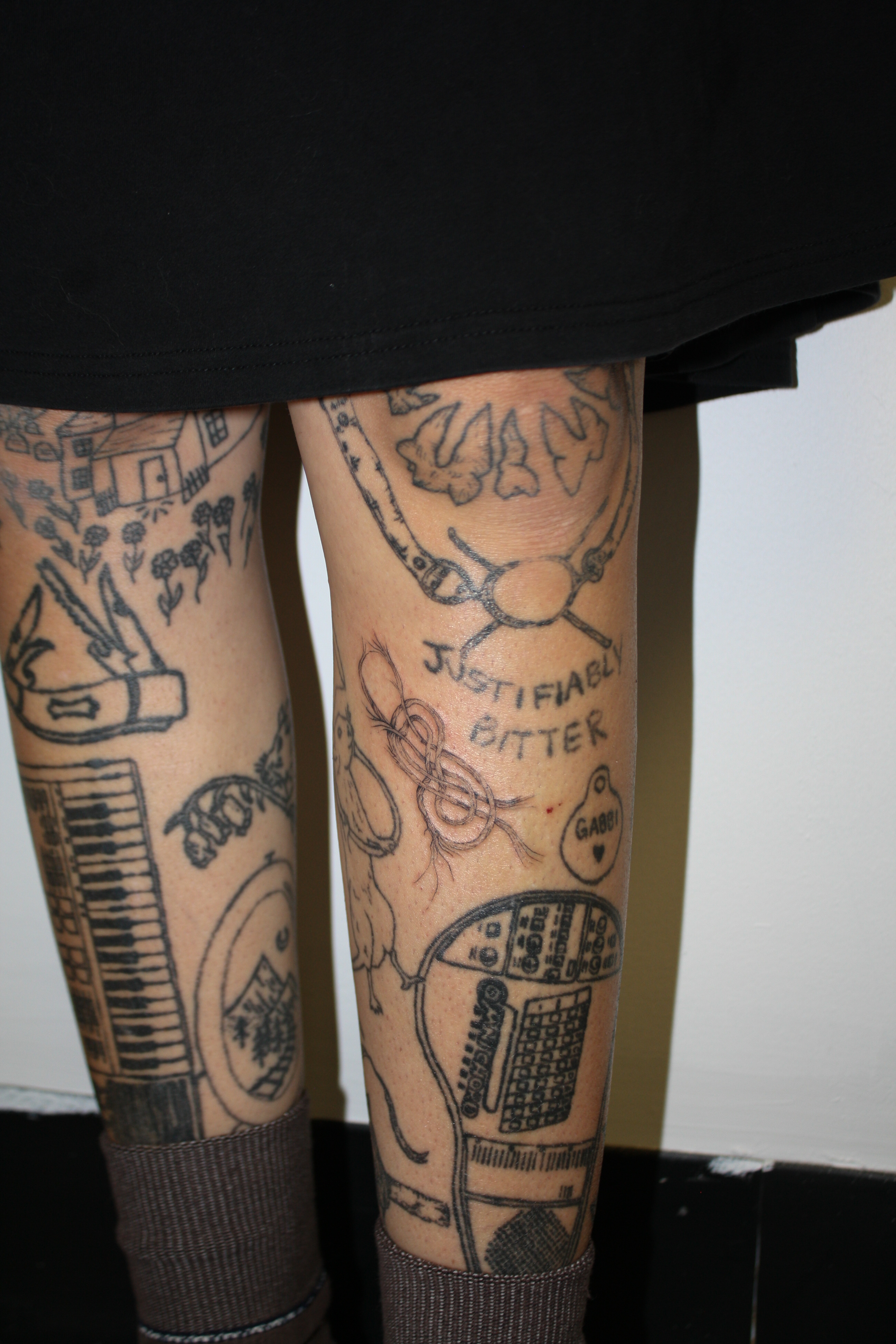 Knot tattoo with fraying rope as a gap filler between other tattoos on the shin.