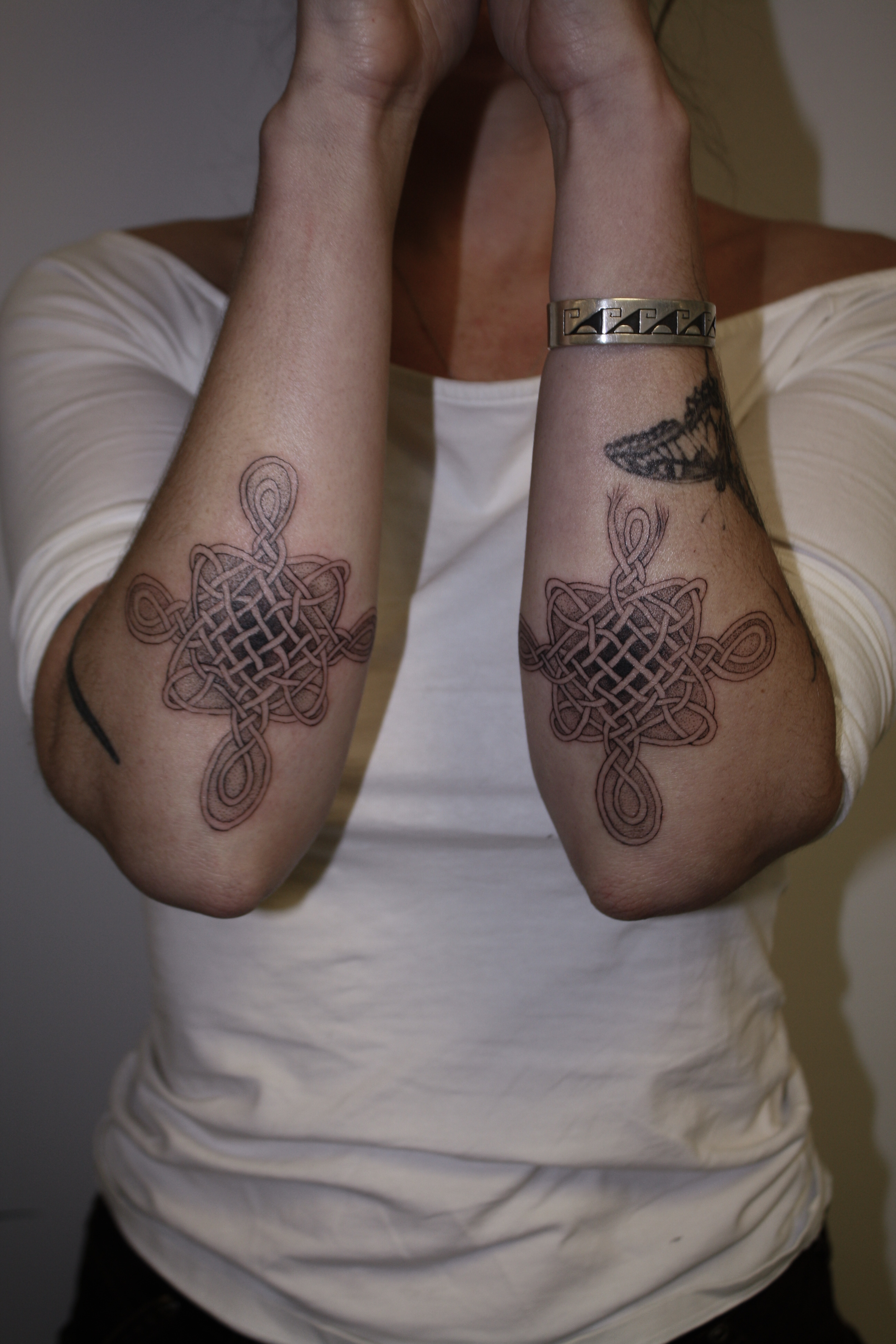 Matching Celtic knots on each arm of client below elbows 