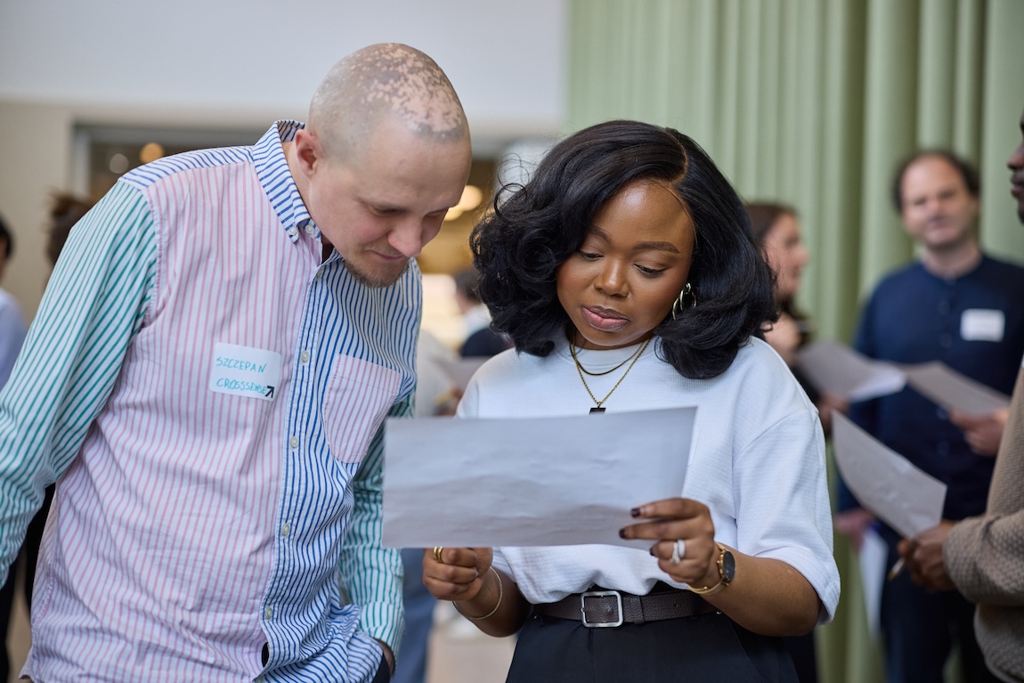 Founders from the Spring 2026 cohort looking at a piece of paper 