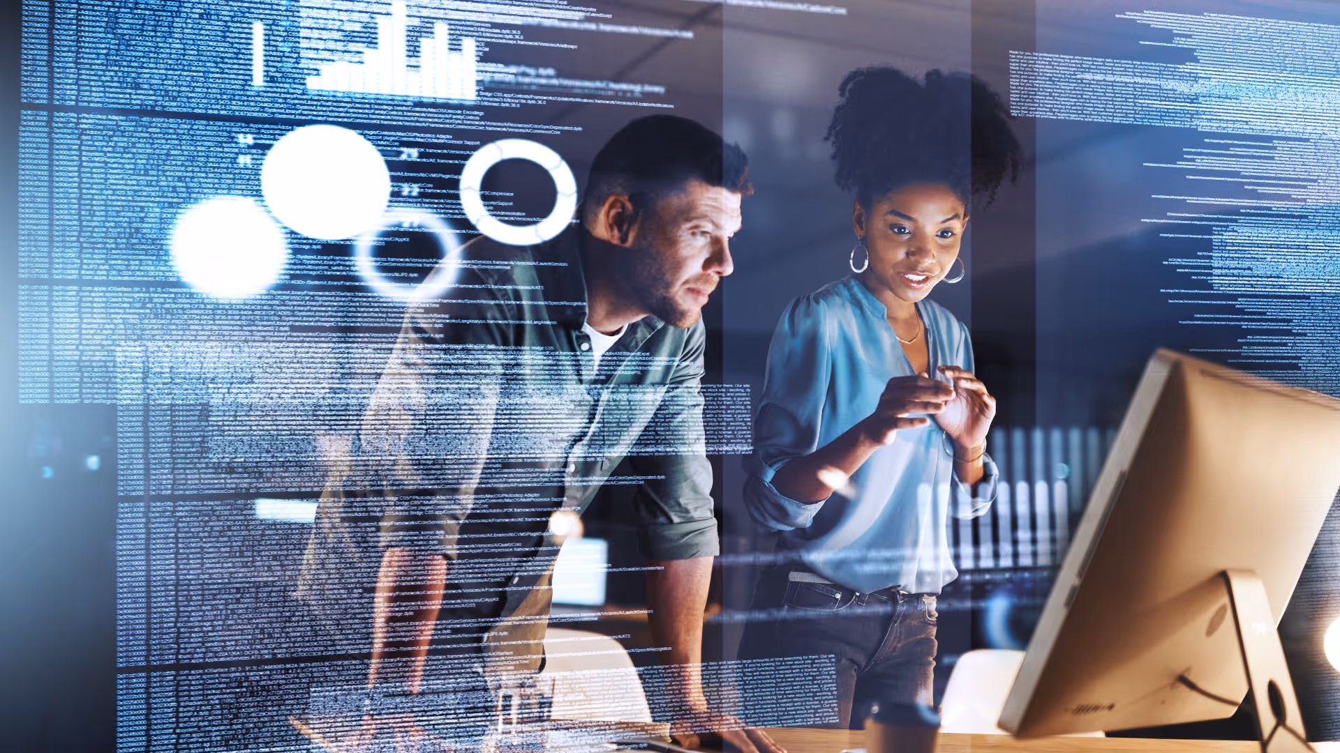 Two professional people staring at a computer screen with an overlay of data