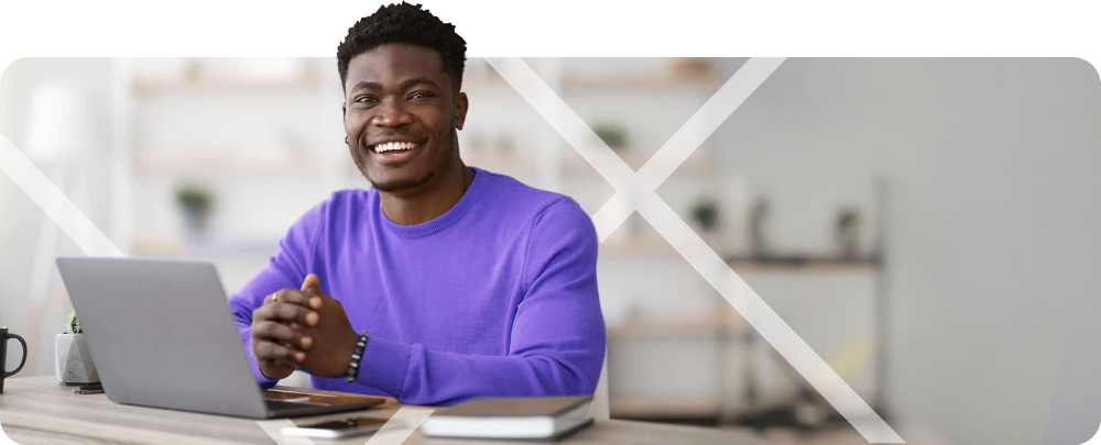 Man sitting infront of a laptop, smiling - First Technology Datacentre & Cloud Workshops