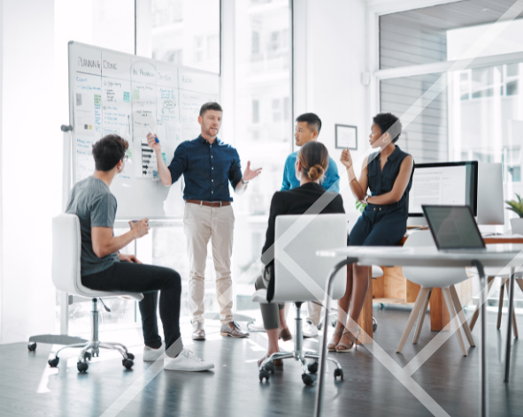 Team of professional people sitting and standing around a whiteboard in a large office with big windows