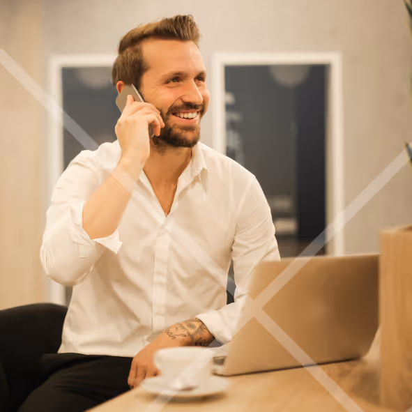Man talking on a phone sitting at a laptop First Technology Cyber Security Solutions