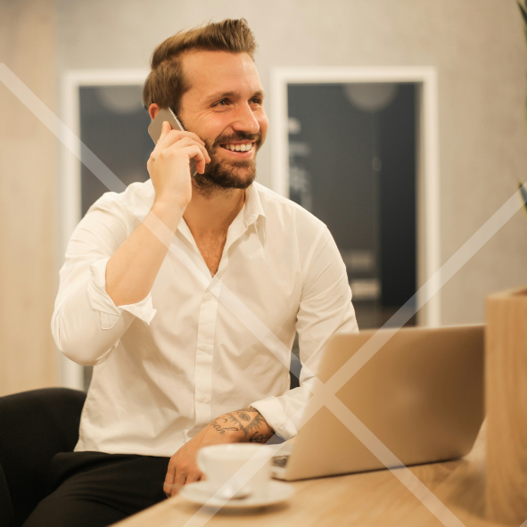 Man talking on a phone sitting at a laptop First Technology Cyber Security Solutions